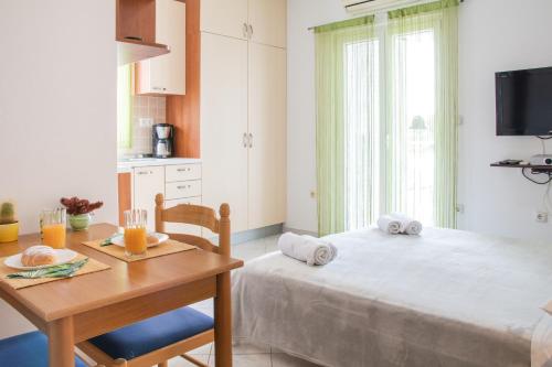 布羅達里卡的住宿－科里納別墅公寓，一间带桌子、床和桌子的卧室以及一间厨房