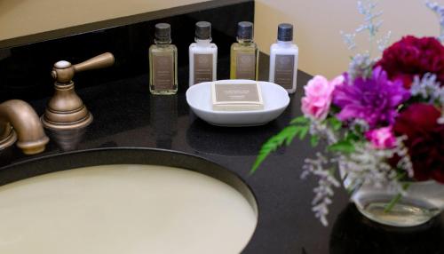 una encimera con lavabo y flores. en Athenaeum Hotel en Chautauqua