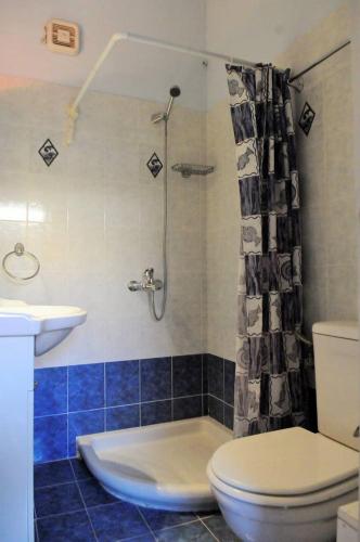 a bathroom with a toilet and a sink and a shower at Melpomeni Villa in Mythimna