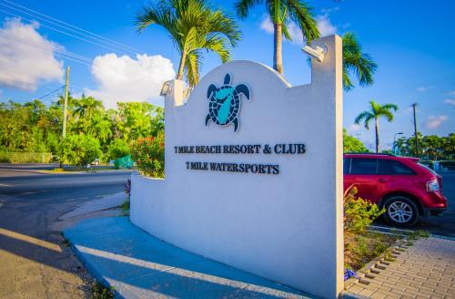 a sign for the turtle beach resort and club at Seven Mile Beach Resort in George Town