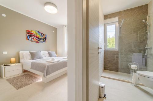 a bedroom with a king sized bed and a bathroom at Villa Splendor in Čilipi