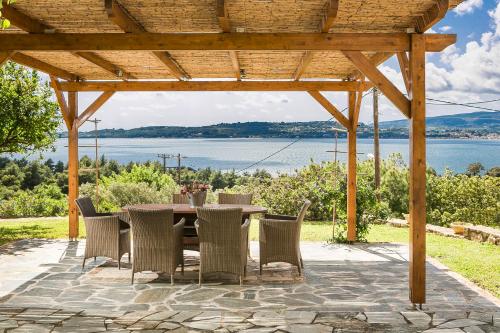 a wooden pergola with a table and chairs at Panorama Fanari studios and apartments in Argostoli