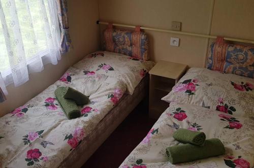 two twin beds in a room with flowers at Chatka pod Tatrami in Mlynčeky