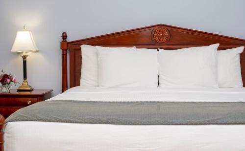 a bedroom with a bed with white sheets and pillows at Athenaeum Hotel in Chautauqua