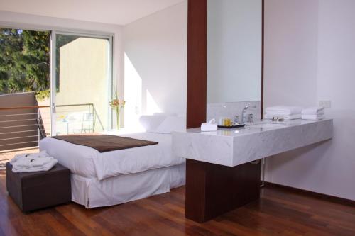 a bedroom with a white bed and a sink at San Isidro Plaza Hotel in San Isidro