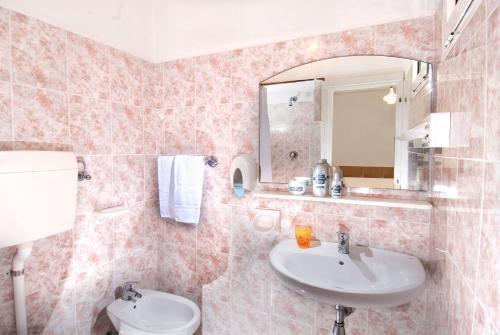 bagno con lavandino e specchio di Hotel Corallo a Misano Adriatico