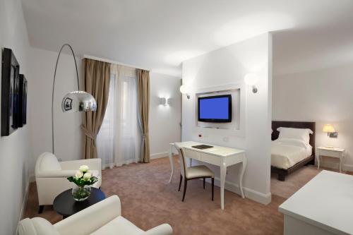 a hotel room with a bed and a desk with a tv at Maison Milano | UNA Esperienze in Milan