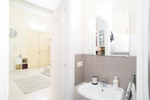 Casa Napoletana - Alighieri في نابولي: حمام أبيض مع حوض ومرآة