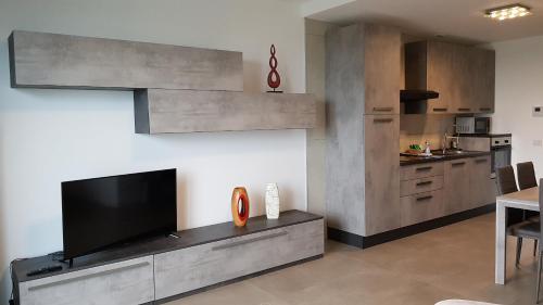 a living room with a tv and a kitchen at Condominio La Torre 1 in Galliate