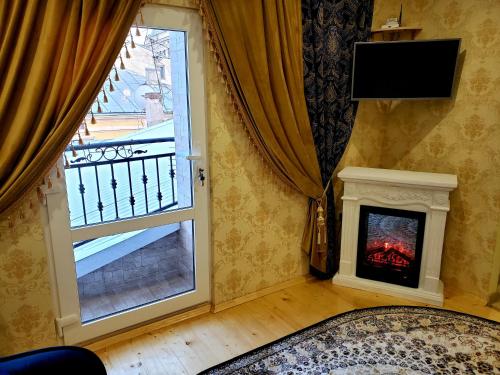 un salon avec une cheminée et une fenêtre dans l'établissement Little Paris Apartment, à Tchernivtsi