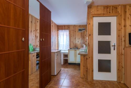 una cucina con pareti in legno e porta bianca di U Mamy a Czarna Woda