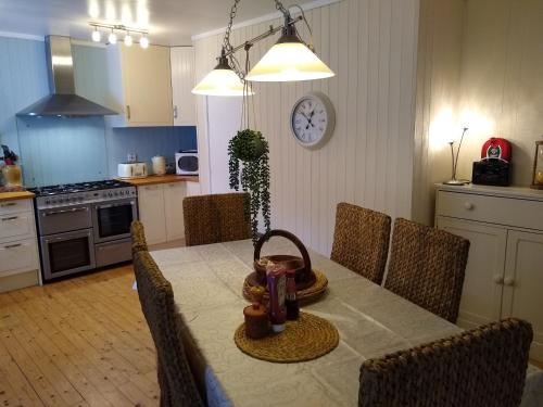 a kitchen with a dining room table with chairs and a tableablish at Drumgarry in Ardvasar