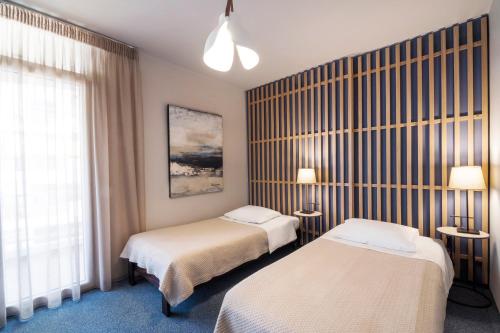 a hotel room with two beds and a window at Marina Alimos Hotel Apartments in Athens