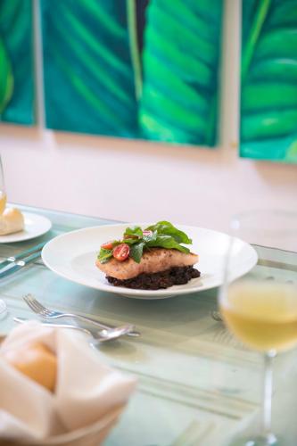 a plate of food on a table with a wine glass at Viva Heavens by Wyndham, A Trademark All Inclusive in San Felipe de Puerto Plata