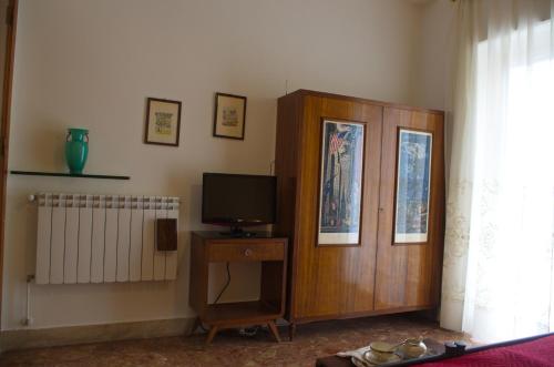 a living room with a tv and a wooden cabinet at Olivarooms in Palermo
