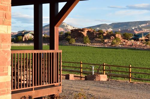 a fence next to a green field with mountains at Cougar Ridge Resort in Torrey
