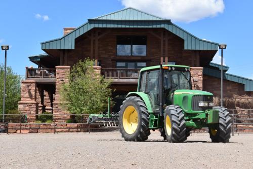 a green tractor parked in front of a building at Cougar Ridge Resort in Torrey
