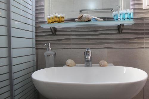 y baño con lavabo blanco y estante. en Vakis Apartments, en Romanón