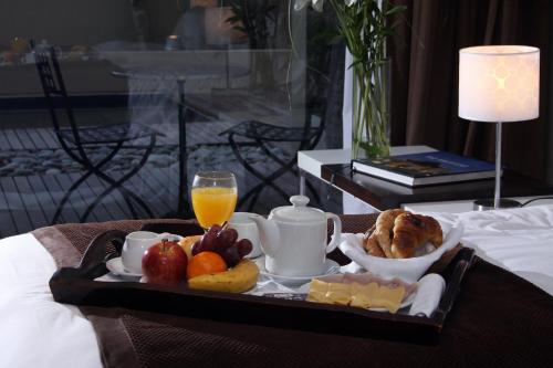 a tray of food with fruit and a glass of orange juice at San Isidro Plaza Hotel in San Isidro