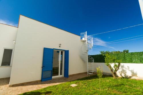a white building with a blue door and a ladder at Stabile Hospitality in Trapani