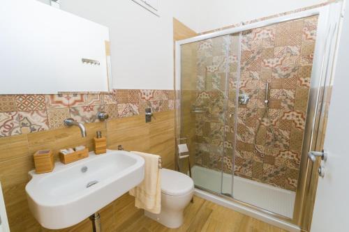 a bathroom with a toilet and a sink and a shower at Stabile Hospitality in Trapani