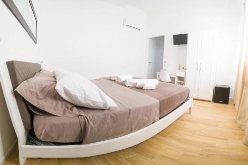 a bed in a white room with a bed frame at Stabile Hospitality in Trapani