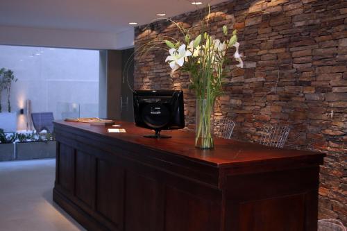 a vase of flowers sitting on top of a counter at San Isidro Plaza Hotel in San Isidro