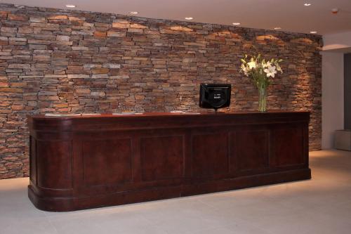 a brick wall with a reception desk and a tv at San Isidro Plaza Hotel in San Isidro
