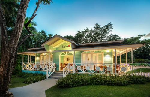 a house with a porch and chairs in the yard at Viva Heavens by Wyndham, A Trademark All Inclusive in San Felipe de Puerto Plata