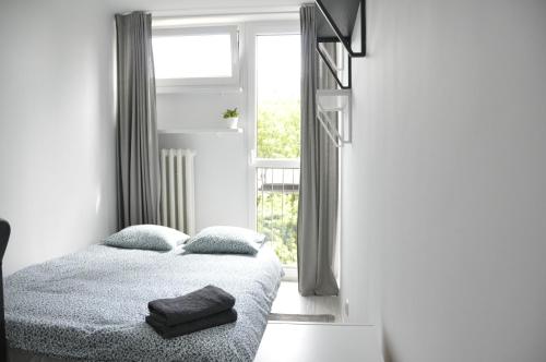 a bedroom with a bed with two pillows and a window at Mario Rooms in Warsaw