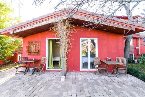 a red house with tables and chairs in front of it at B&B Concha in Becerril de la Sierra