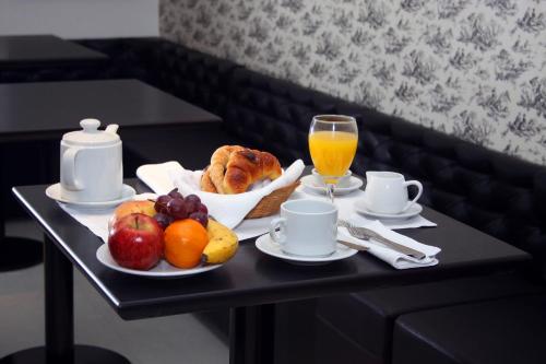 a table with a tray of fruit and bread and a glass of orange juice at San Isidro Plaza Hotel in San Isidro
