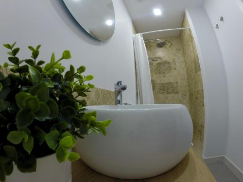 un bagno con lavandino bianco e pianta in vaso di Casa Bonita Médano a El Médano