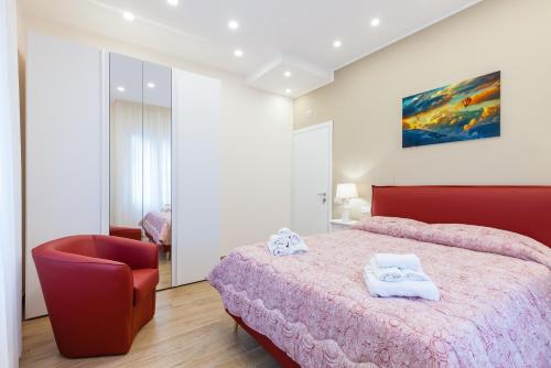 a bedroom with a red bed and a red chair at Sorrento Sweet Sirena 2 in Sorrento