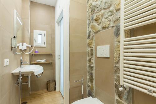 La salle de bains est pourvue d'un lavabo et d'un mur en pierre. dans l'établissement Sorrento Sweet Sirena 2, à Sorrente