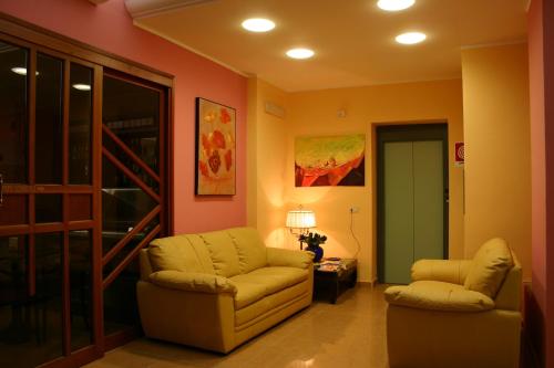a living room with two chairs and a door at Hotel Piro in Torrenova