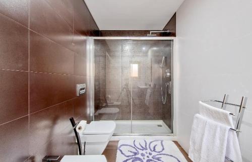 a bathroom with a shower and a toilet and a sink at AZEITÃO DAMAS VILLA in Azeitao