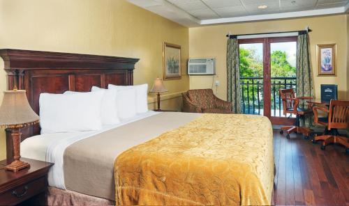 a hotel room with a bed and a balcony at Ocean Inn & Suites in Saint Simons Island