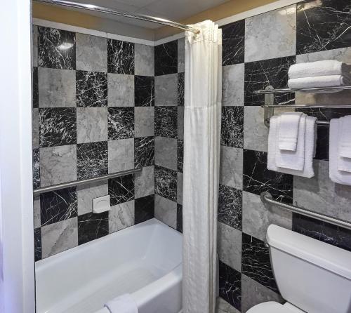 a bathroom with a bath tub and a toilet at Ocean Inn & Suites in Saint Simons Island