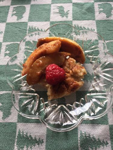 a glass plate of food with a raspberry on a table at Homer Stay and Play in Homer