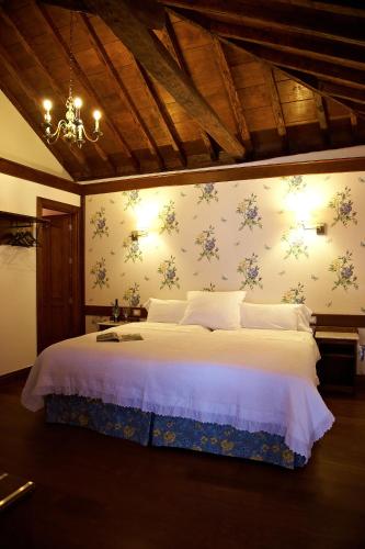a bedroom with a bed with flowers on the wall at Hotel Emblemático San Agustin in Icod de los Vinos