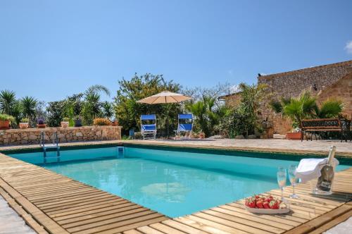 uma piscina com um deque de madeira, uma mesa e cadeiras em Villa Le Rasce em Leuca