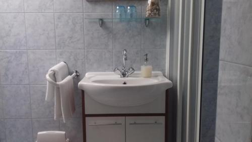 a bathroom with a white sink and a toilet at Sorompó Vendégház in Balatonkenese