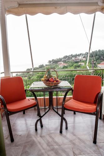 a table and two chairs with a bowl of fruit on it at Nontas Homes in Kalamitsi