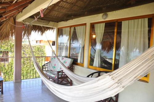 a hammock on the porch of a house at Ananda Guest House Yoga & Meditación in Puerto Escondido