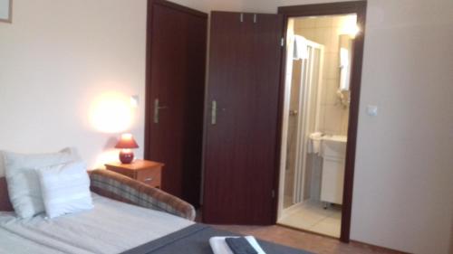 a hotel room with a bed and a door to a bathroom at Sorompó Vendégház in Balatonkenese