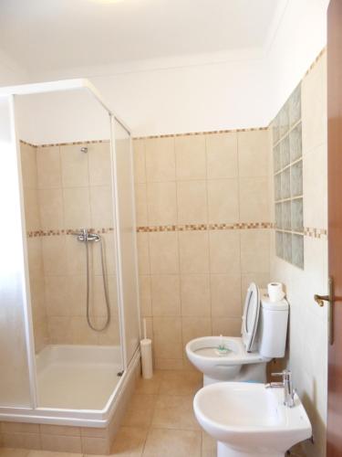 y baño con ducha, aseo y lavamanos. en Casa Margmar en Vila Nova de Milfontes