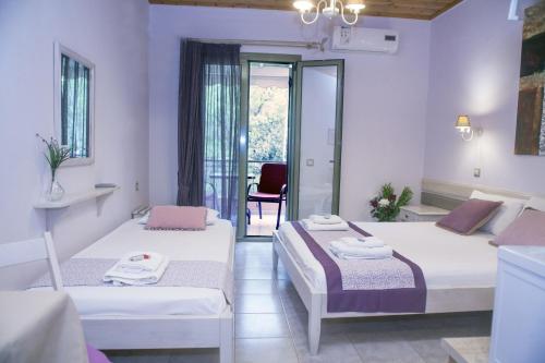 a room with two beds and a table with a chair at Nontas Homes in Kalamitsi