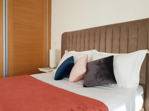 a bedroom with a bed with pillows on it at Appart Aga Hivernage in Agadir