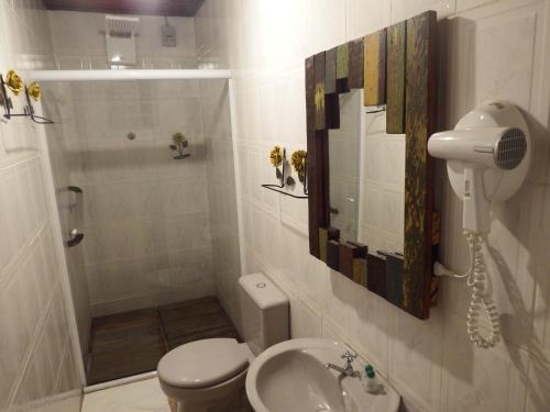 a bathroom with a toilet and a sink and a shower at Pousada Chalés da Felicidade in Itu